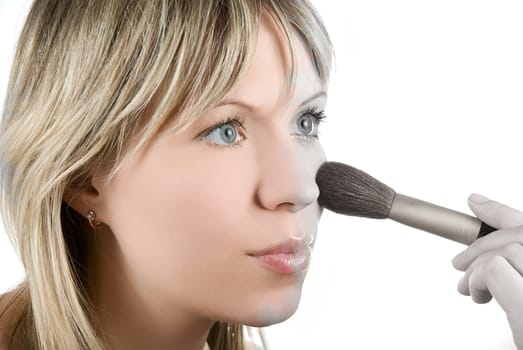 Girl with brush painting her face on white