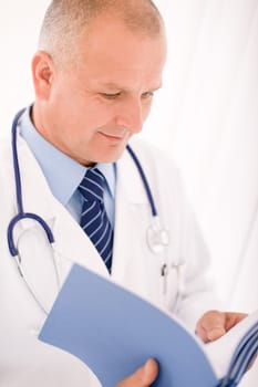 Professional senior doctor male with stethoscope look down document folders