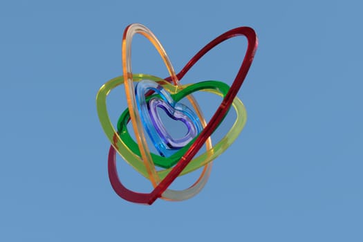 six heart shaped plastic pieces one inside the other on a blue background as if floating on air
