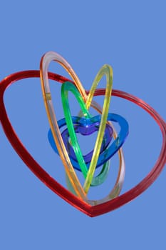 six heart shaped plastic pieces one inside the other on a blue background as if floating on air