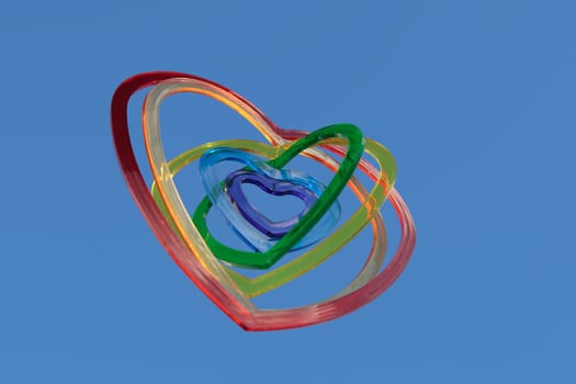 six heart shaped plastic pieces one inside the other on a blue background as if floating on air