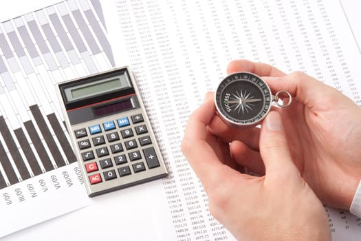 Navigate to success in business and compare right direction in business concept. Man with compass directed to success word. Calculator, sheet and graph represent business.