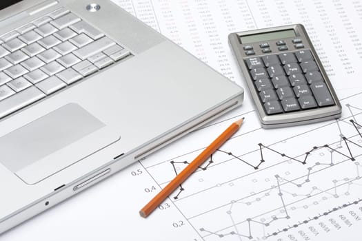 Business analyze with laptop, calculator and printed data sheet