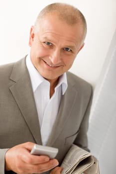 Handsome mature businessman smiling holding phone close-up professional portrait
