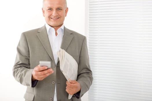 Handsome mature businessman smiling holding phone close-up professional portrait