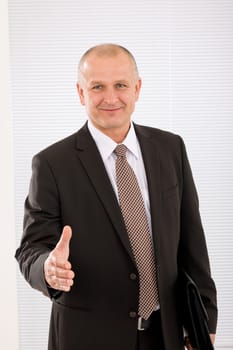 Successful mature executive businessman giving handshake close deal portrait