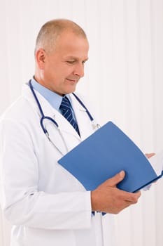 Professional senior doctor male with stethoscope look down document folders