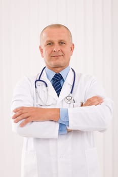 Portrait of mature professional doctor male with stethoscope crossed arms