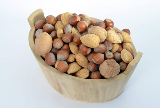 Hazelnuts, walnuts and almonds in a wood basket isolated on white background