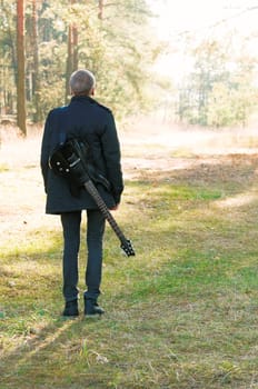 teen musician with a guitar in the autumn forest