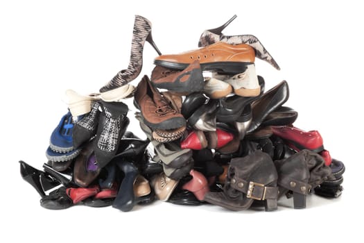 Pile of old female and male footwear isolated over white background