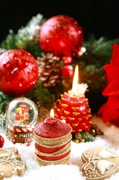 Beautiful Christmas candle with gingerbread on the snow