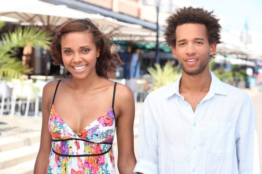 Young couple walking past restaurants in the summer