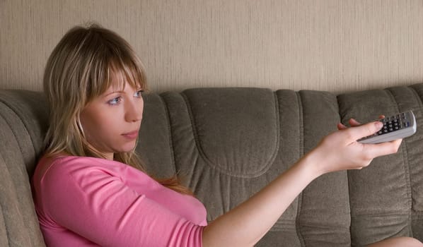 Girl sitting on the sofa and watching tv
