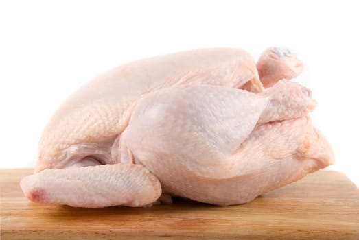 Raw chicken at wood table isolated on white