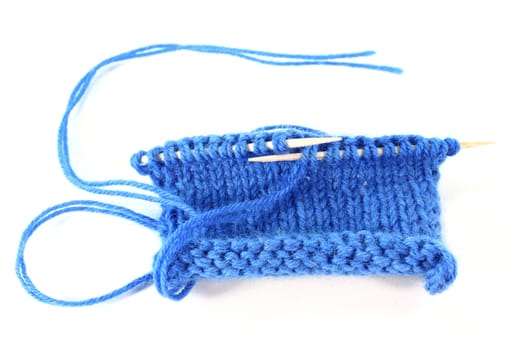 a blue knitting sample against a white background