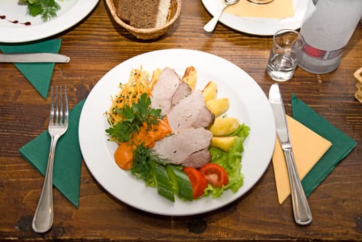At Restaurant: tasty meat dish at wooden table