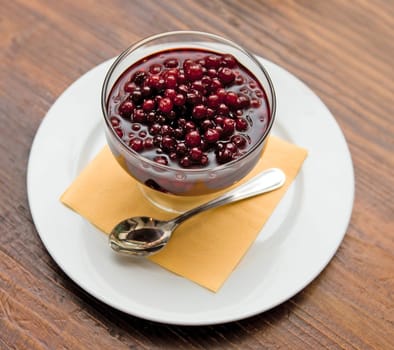 Fresh cranberries dessert on wooden table background