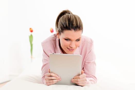 young woman with tablet on sofa at home