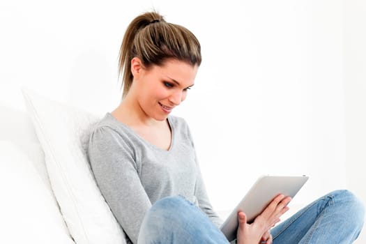 beautiful woman with tablet on sofa at home