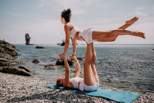 Woman sea yoga. Back view of free calm happy satisfied woman with long hair standing on top rock with yoga position against of sky by the sea. Healthy lifestyle outdoors in nature, fitness concept.