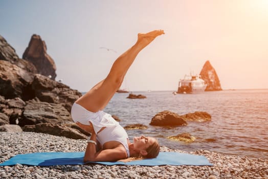 Woman sea yoga. Back view of free calm happy satisfied woman with long hair standing on top rock with yoga position against of sky by the sea. Healthy lifestyle outdoors in nature, fitness concept.