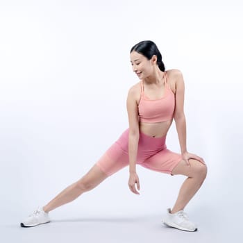 Young attractive asian woman in sportswear stretching before fitness exercise routine. Healthy body care workout with athletic woman warming up on studio shot isolated background. Vigorous