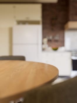 Kitchen with an emphasis on the surface of the kitchen table with a blurred background - a place to place products. L-shaped kitchen with beams and dining table. 3D rendering