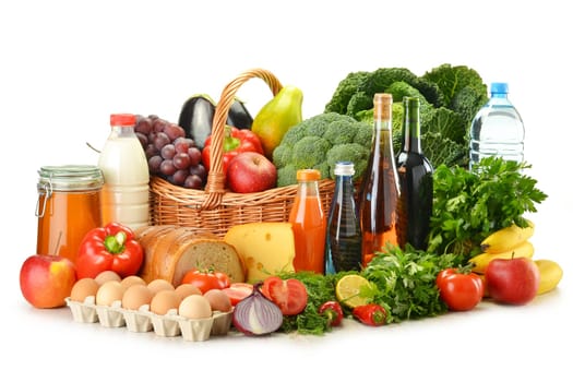 Groceries in wicker basket including vegetables, fruits, bakery and dairy products and wine isolated on white