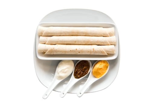 Flat cake and assortment of spices in the spoons on white background