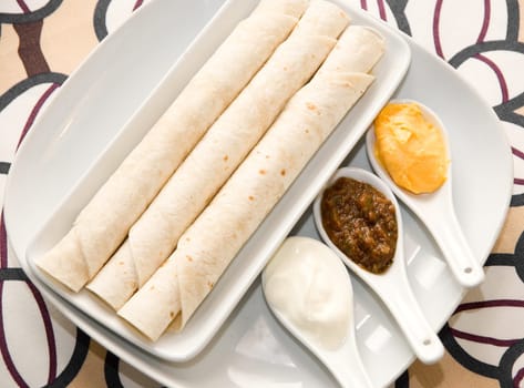 Flat cake and assortment of spices in the spoons. Close up.