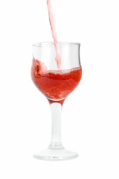 Red wine being poured into a wine glass isolated on white