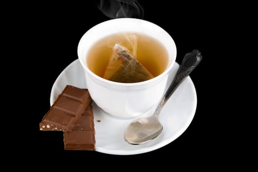 a sweets chocolate with cup of the tea on black