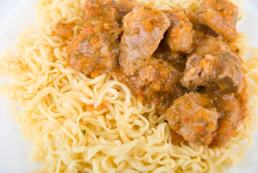 Close up of portion of spaghetti in a dish with fork on white background