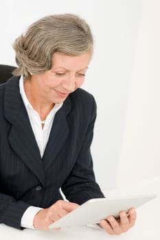 Elegant senior businesswoman working on touch-screen tablet computer