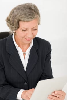 Elegant senior businesswoman working on touch-screen tablet computer