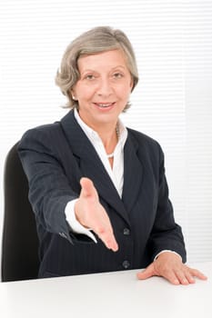 Happy senior successful businesswoman giving handshake close deal