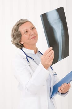 Happy senior doctor female looking at x-ray with stethoscope portrait
