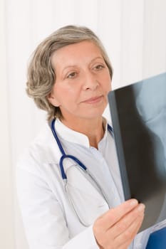 Senior doctor female hold and looking at x-ray with stethoscope