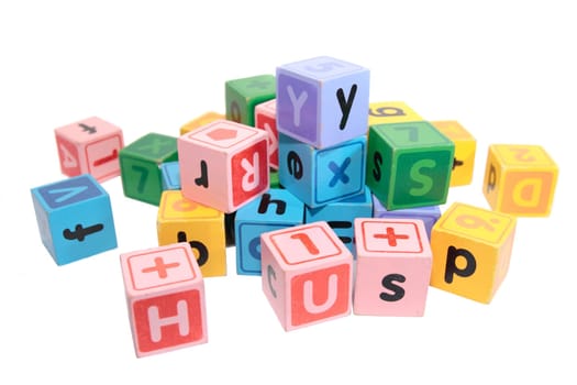 assorted childrens toy letter building blocks against a white background