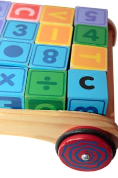 childrens toy letter building blocks all together in a toy cart isolated on white background