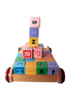 childrens toy letter building blocks all together in a toy cart isolated on white background