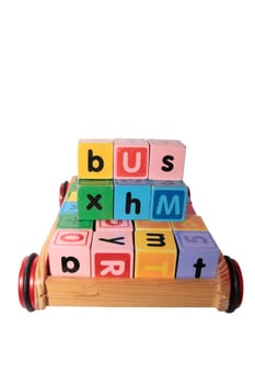 childrens toy letter building blocks all together in a toy cart isolated on white background