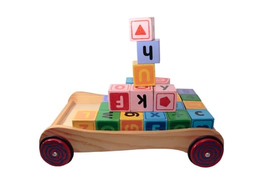 childrens toy letter building blocks all together in a toy cart isolated on white background