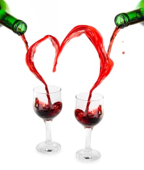 Heart from pouring red wine in goblets isolated on white