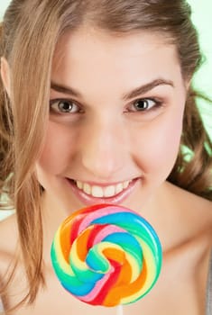 Portrait of smiling teenager girl holding colorful lollipop