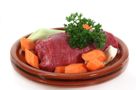 raw roast beef with vegetables in a tagine
