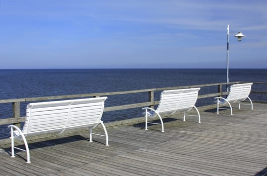 White benches on the pier of the seaside resort of Bansin,Usedom Island,Mecklenburg-Western Pomerania,Germany