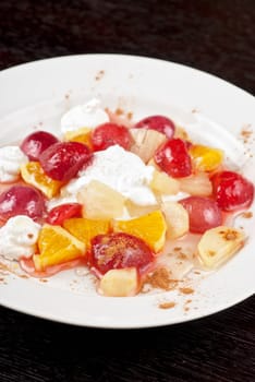 tasty fruit salad of pineapple, grape, orange and strawberry with whipped cream