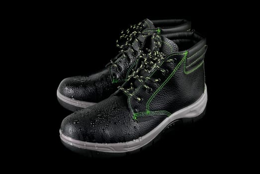 moist modern working boots isolated on a black background